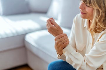 senior woman suffering from pain in hand at home