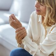 senior woman suffering from pain in hand at home