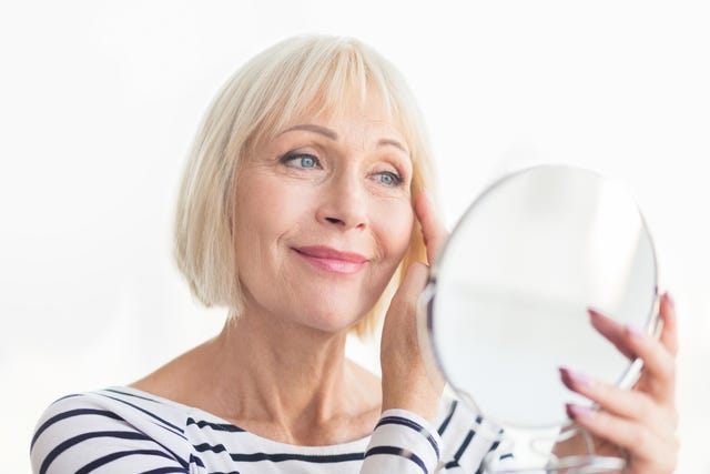 Senior woman touching her soft face skin