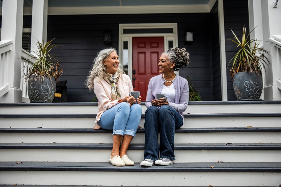 senior women having coffee in front of suburban home