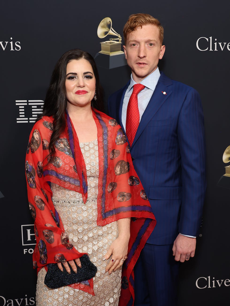 tyler childers posing with his wife senora may for a photo in front of a grammys backdrop