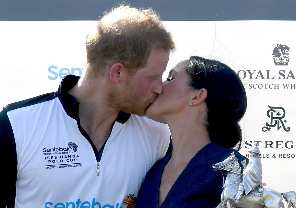 windsor, united kingdom july 26 meghan, duchess of sussex and prince harry, duke of sussex kiss as they pose with the trophy after the sentebale isps handa polo at the royal county of berkshire polo club on july 26, 2018 in windsor, england photo by anwar husseinwireimage