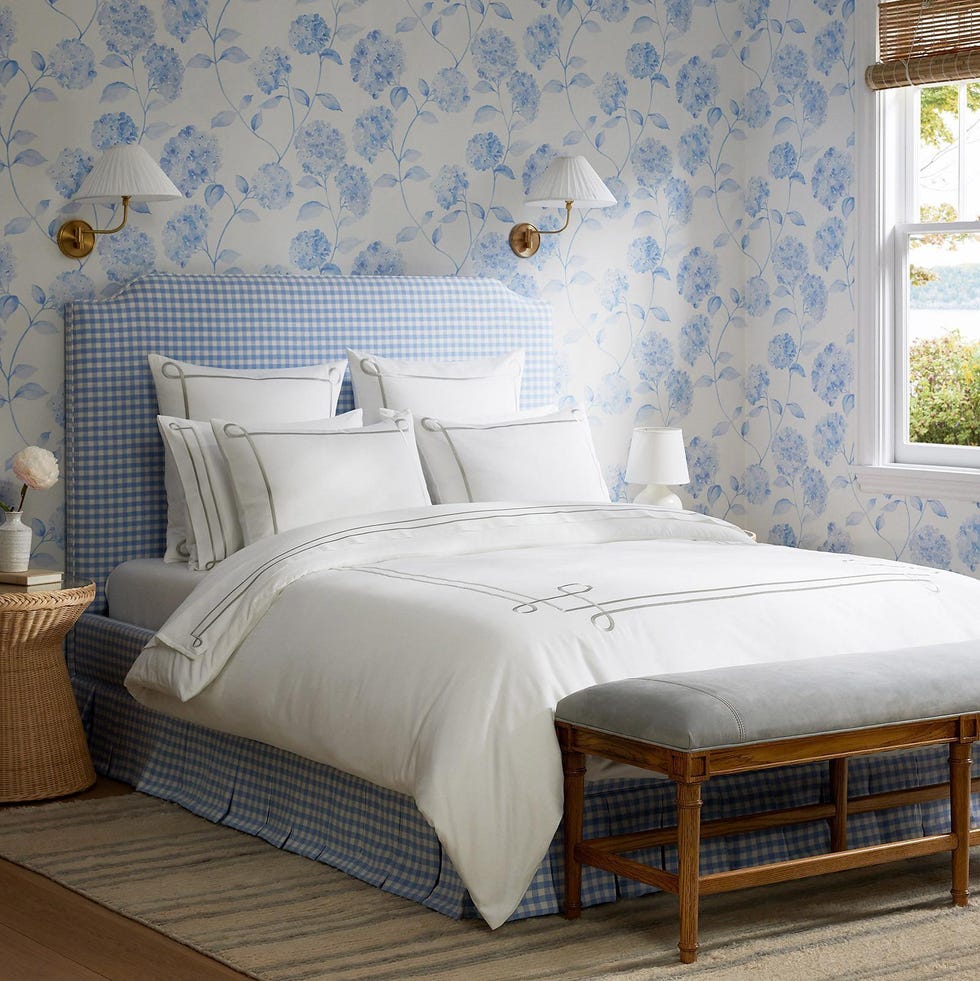 a bed with a blue and white wallpaper a bed with a blue and white wallpaper
