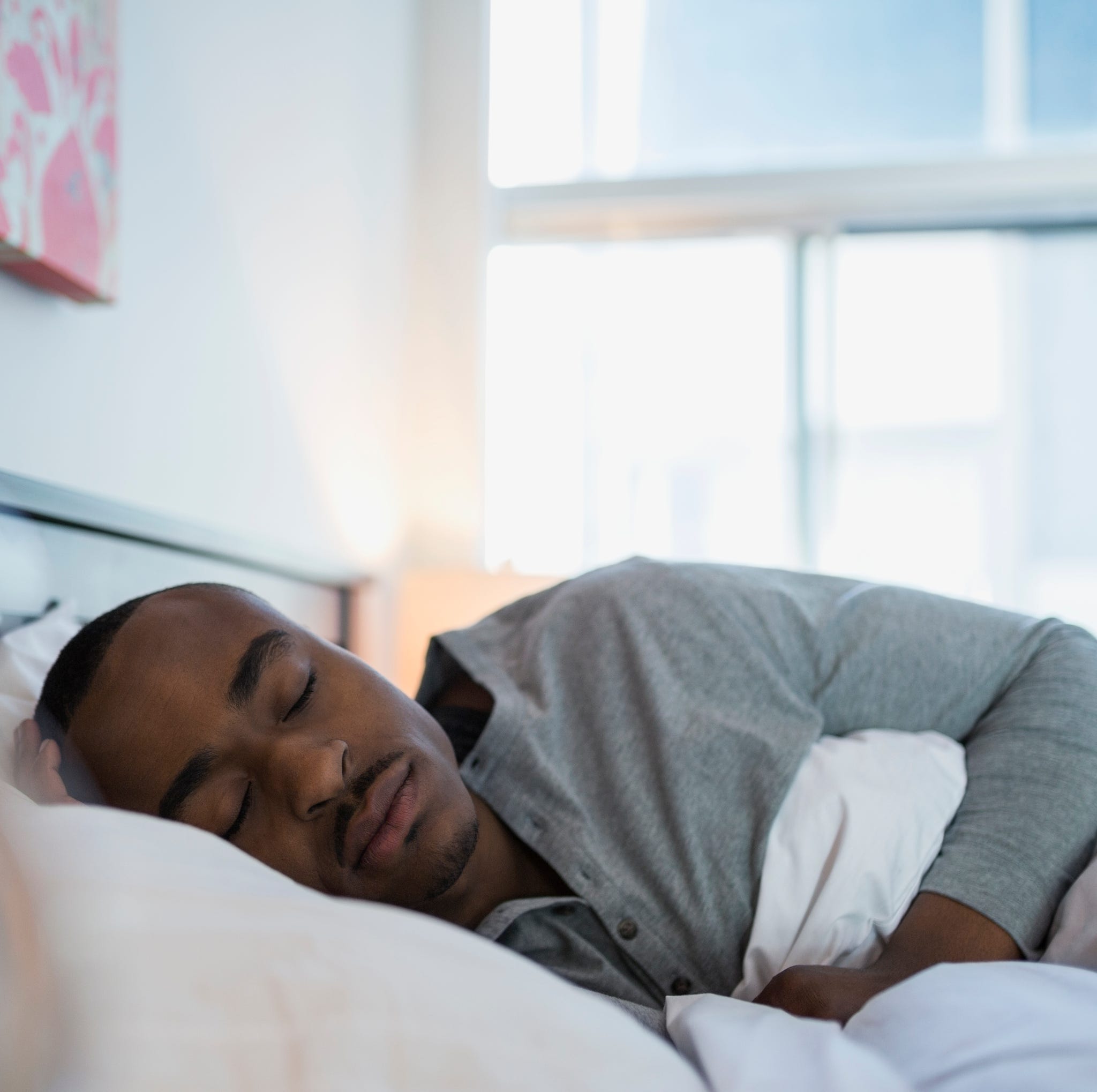 Serene man sleeping in bed in the morning