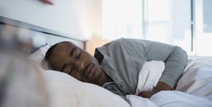 Serene man sleeping in bed in the morning