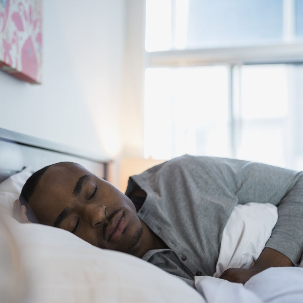 Serene man sleeping in bed in the morning