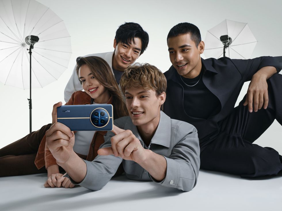 ragazzi scattano fotografia di gruppo con smartphone realme 12 pro blue