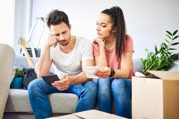 una pareja, muy seria, hace cuentas calculadora en mano