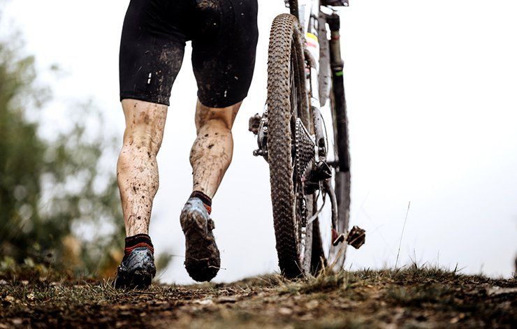 A muddy cyclist. 