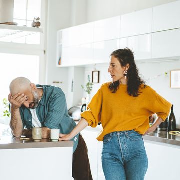 serious woman arguing with man in kitchen at home
