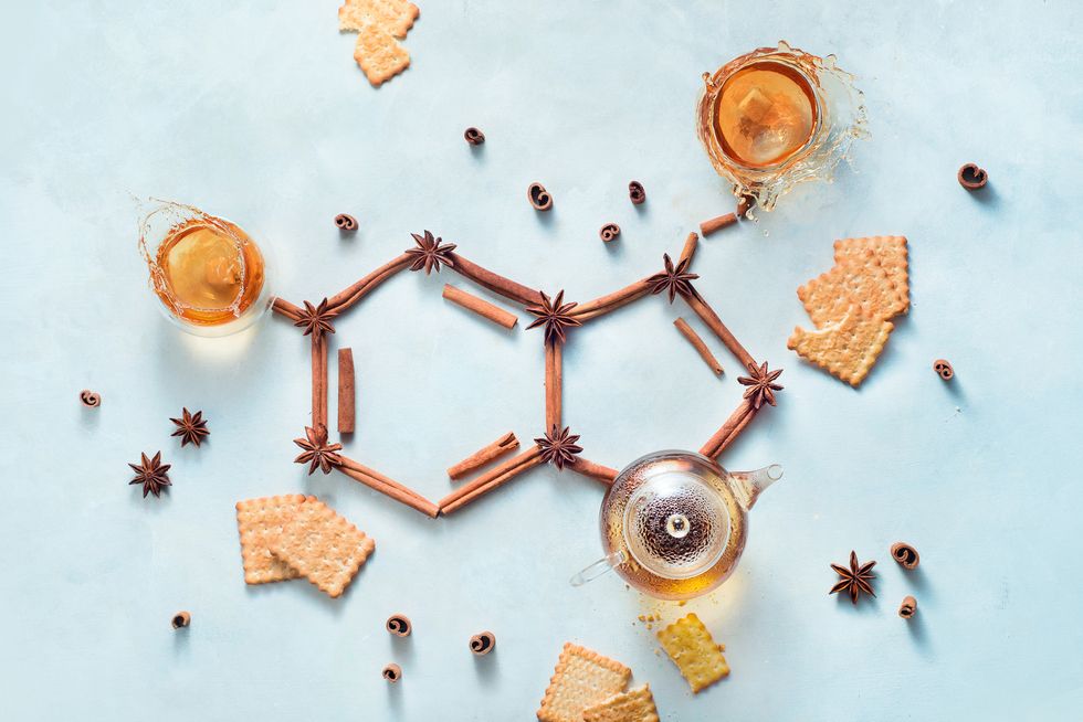 serotonin molecule made out of cinnamon and teacups with splashes creative drink flat lay with the hormone of joy