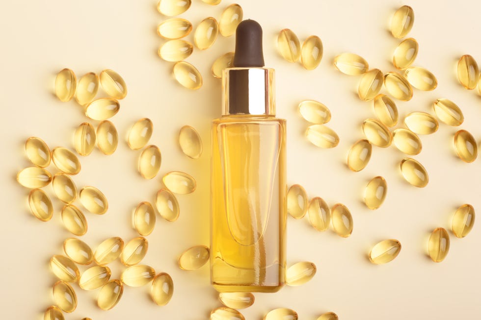 serum glass bottle with pipette and many omega 3 pills on the beige background natural organic spa cosmetic concept flat lay photo