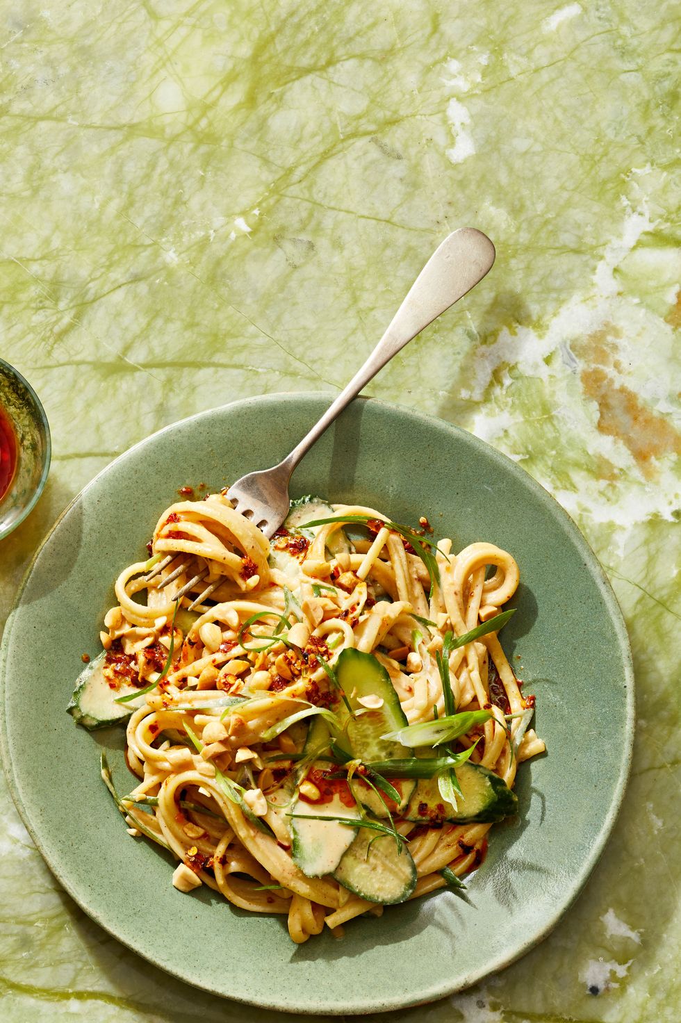 sesame noodles with peanuts and cucumber on top