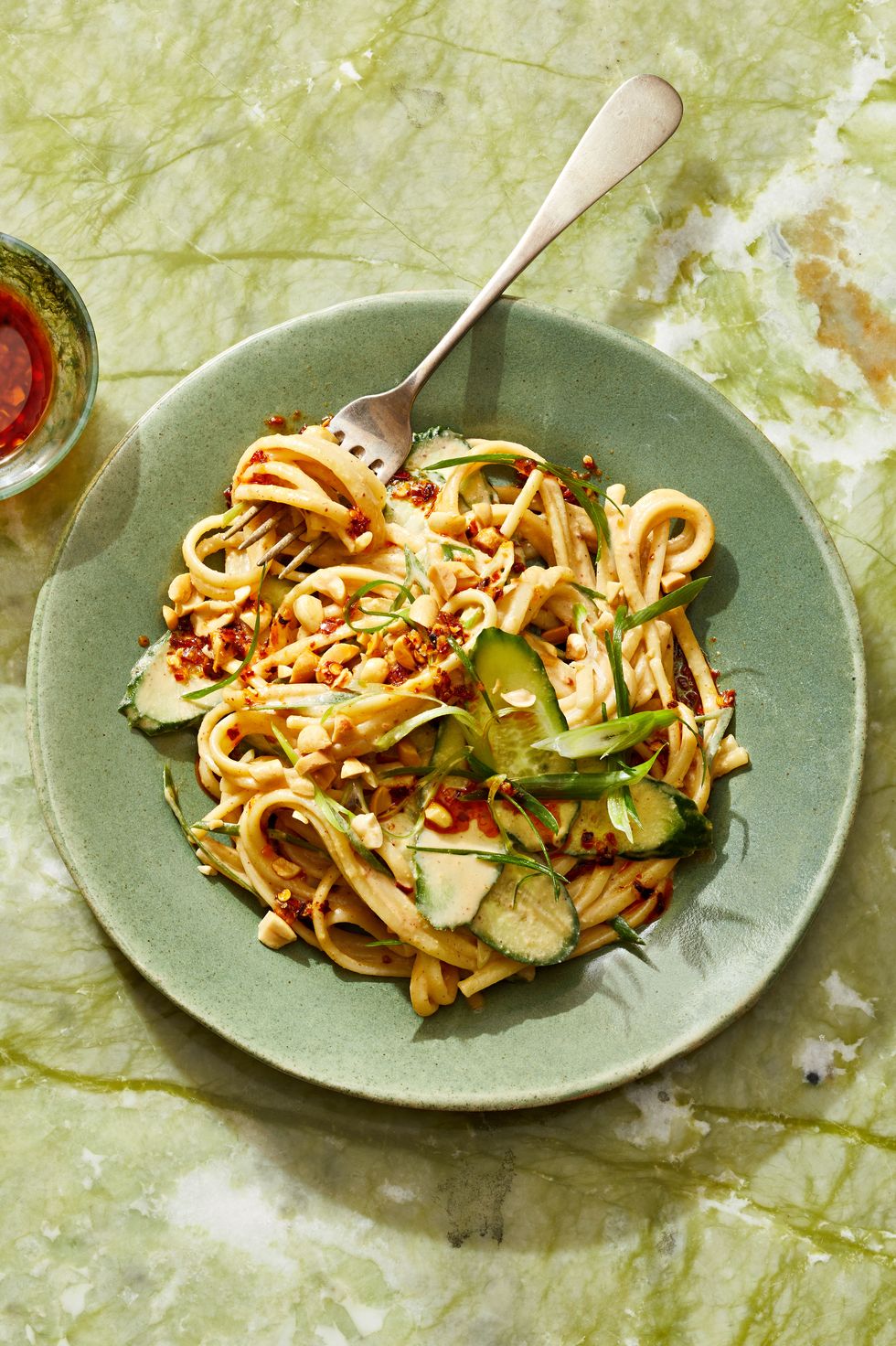 sesame noodles with peanuts and cucumber on top