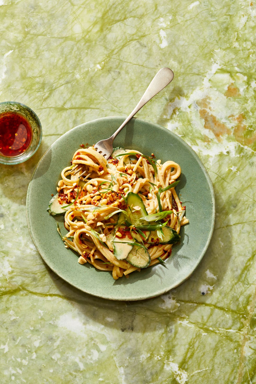 sesame noodles with peanuts and cucumber on top