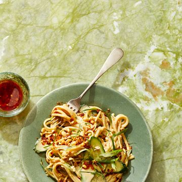 sesame noodles with crushed peanuts and sliced cucumber on top