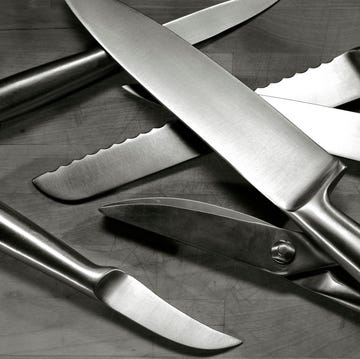Set of stainless steel knives arranged on wooden cutting board set of stainless steel knives arranged on wooden cutting board