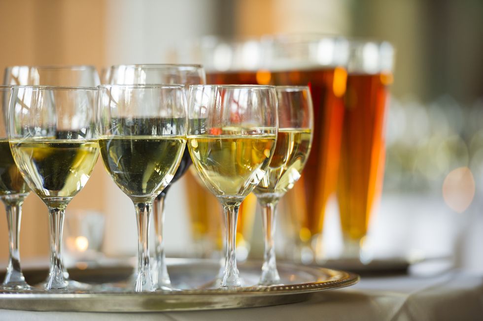 several glasses of wine and beer on a serving tray