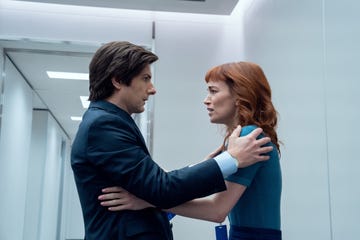 a man and a woman standing close together in a modern office setting engaging in a personal moment