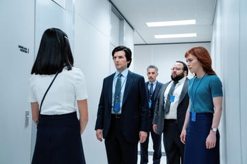 group of professionals engaging in a conversation in an office corridor