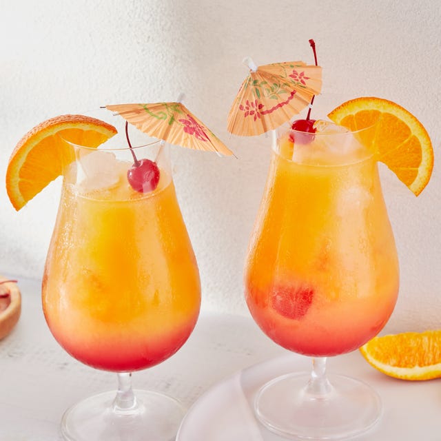 ombre red and orange sex on the beach cocktail garnished with an orange slice, a maraschino cherry, and a cocktail umbrella