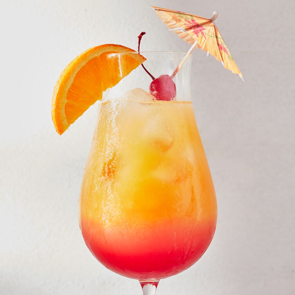 ombre red and orange sex on the beach cocktail garnished with an orange slice, a maraschino cherry, and a cocktail umbrella