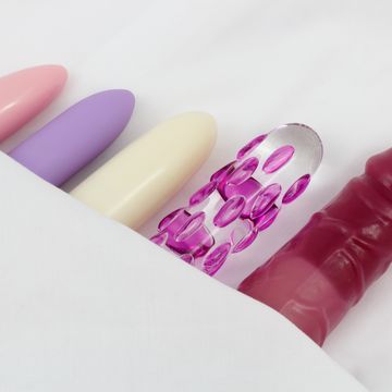 Sex Toys - Glass dildo and vibrators in bed