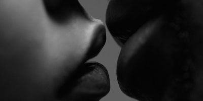 couple man and woman kissing black and white focus