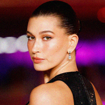 hailey bieber photographed in black dress with her hair slicked back in bun