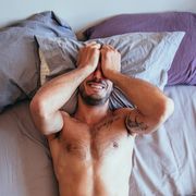 sexy man covering face in bed, sexy man lying in bed