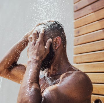 mid adult man taking a shower outdoors mid adult man taking a shower outdoors