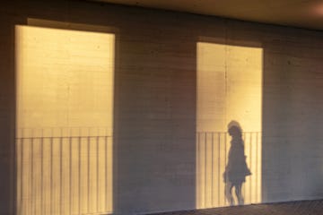 shadow of a person reflected on the wall of a building