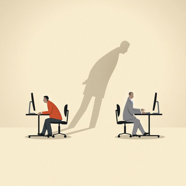 Shadow of businessman spying on colleague using computer