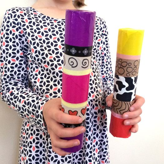 a kid holds up a cardboard shaker tube
