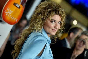 shania twain smiles at camera in blue dress