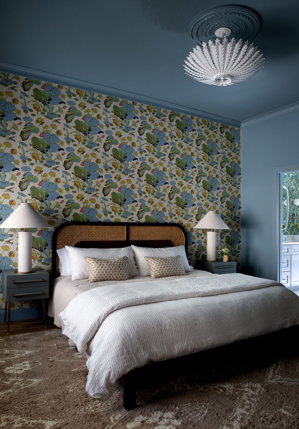 bedroom with colorful leaf wallpaper and symmetrical bedside tables