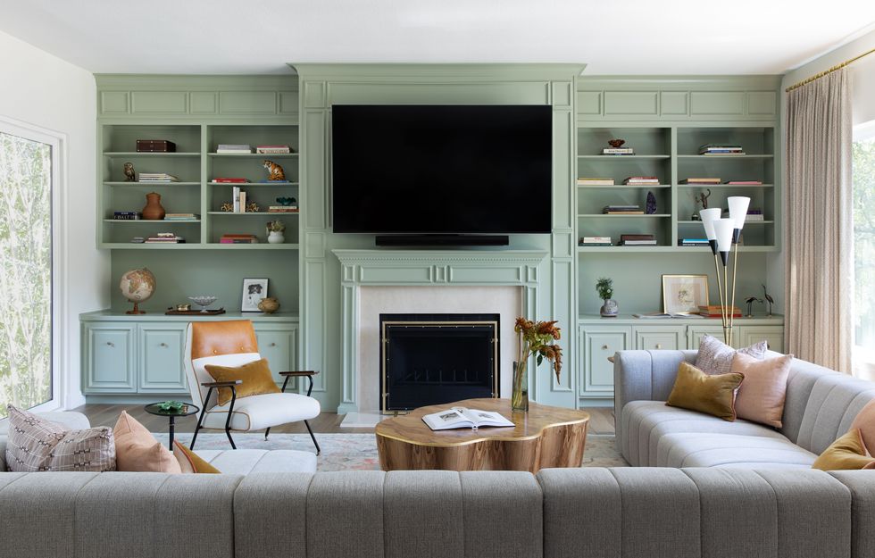 living room with grey sectional and green built in shelving