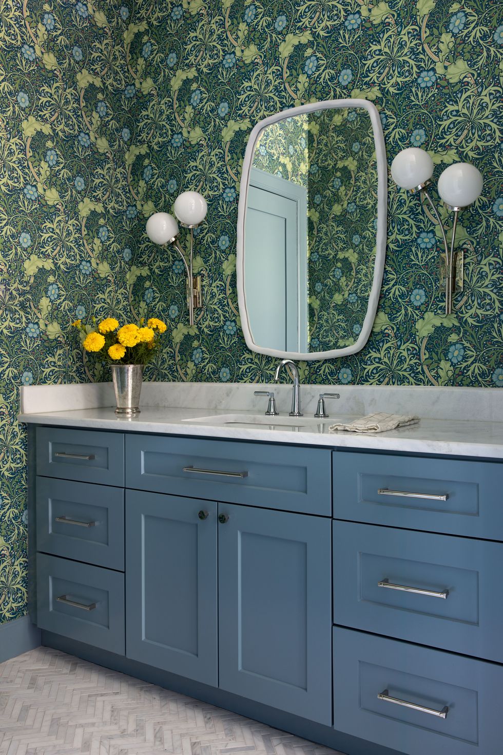 bathroom with blue cabinet and green floral wallpaper