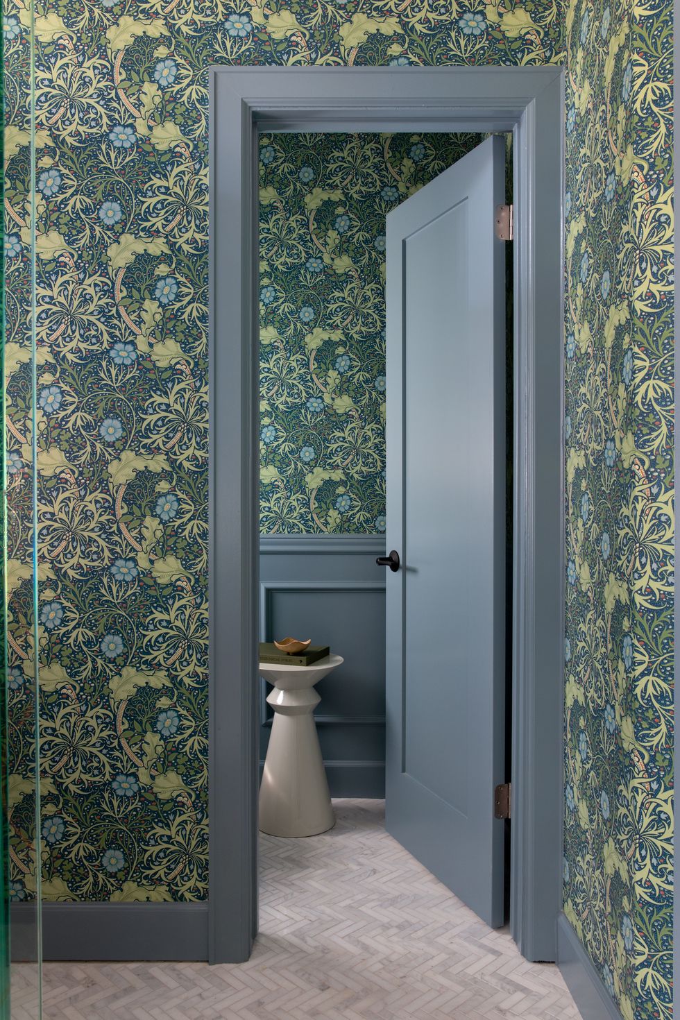bathroom walls covered in green botanical wallpaper