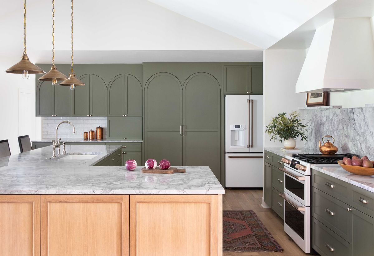 kitchen, olive green cabinets, wooden island with marble countertop, white oven, white range hood