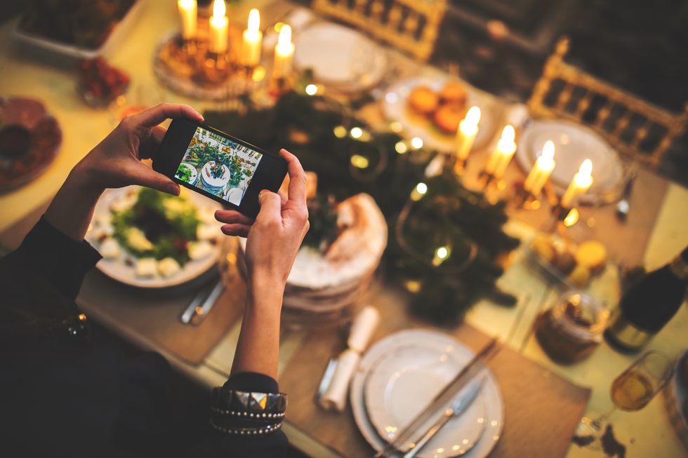 Woman takes photograph of Christmas table setting