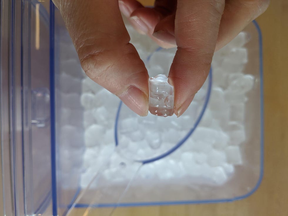 hand holding nugget ice above a drawer filled with more nugget ice