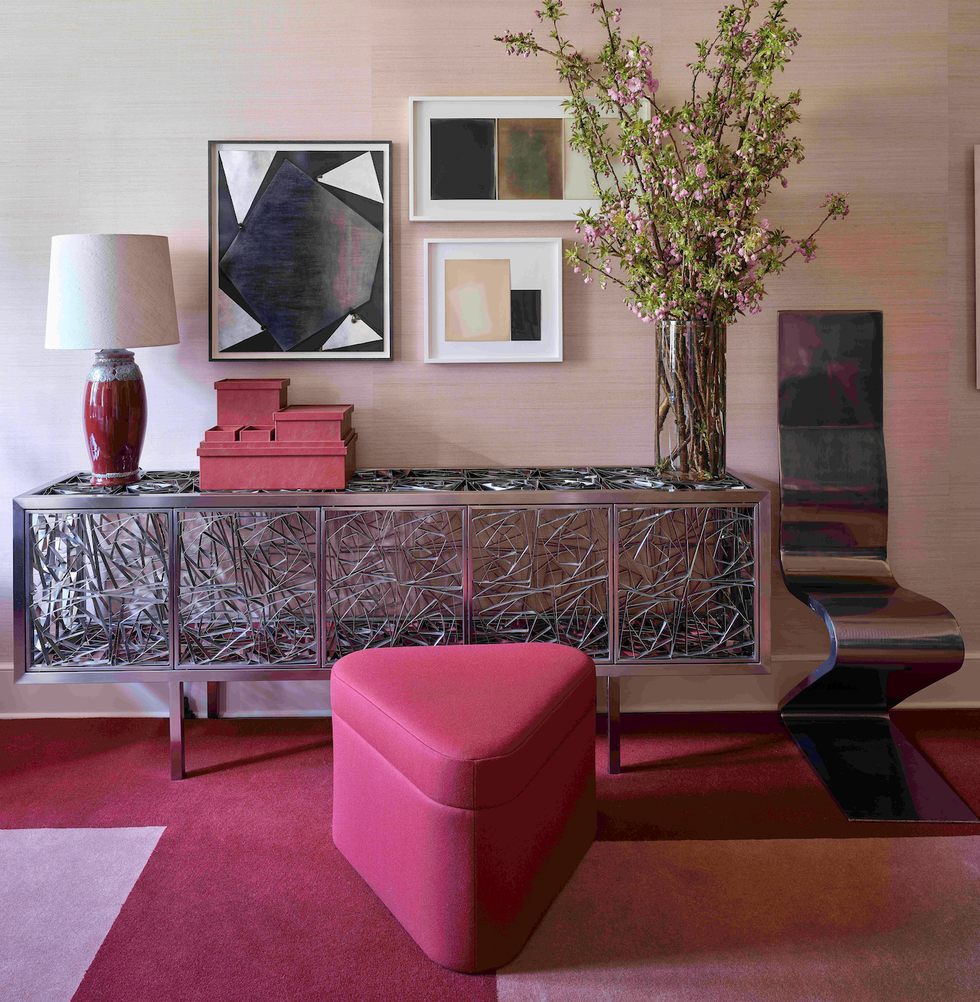 a room with a pink chair and a pink ottoman