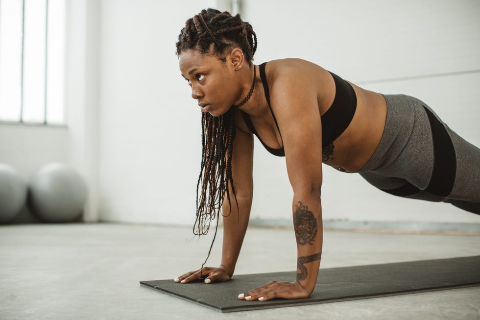 Young Sexy Slim Fitness Woman Doing Push-ups On Wall Background