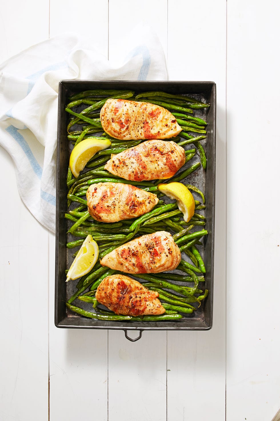 pancetta wrapped chicken with green beans on a sheet pan