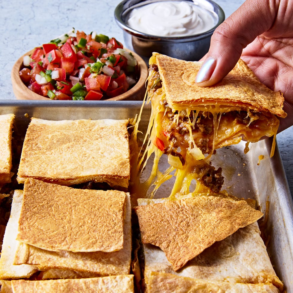 tortillas filled with meat and cheese on a sheet pan