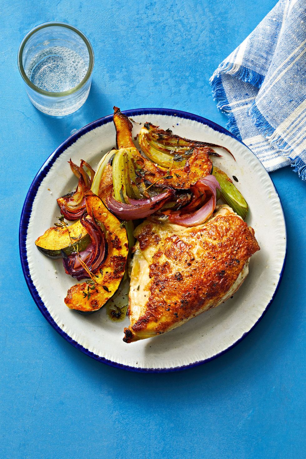 roasted chicken with grilled vegetables on a white plate