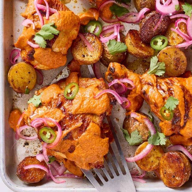 Sheet-Pan Tikka Masala chicken thighs covered in a tikka masala sauce with pickled red onions and jalapenos on a sheet pan
