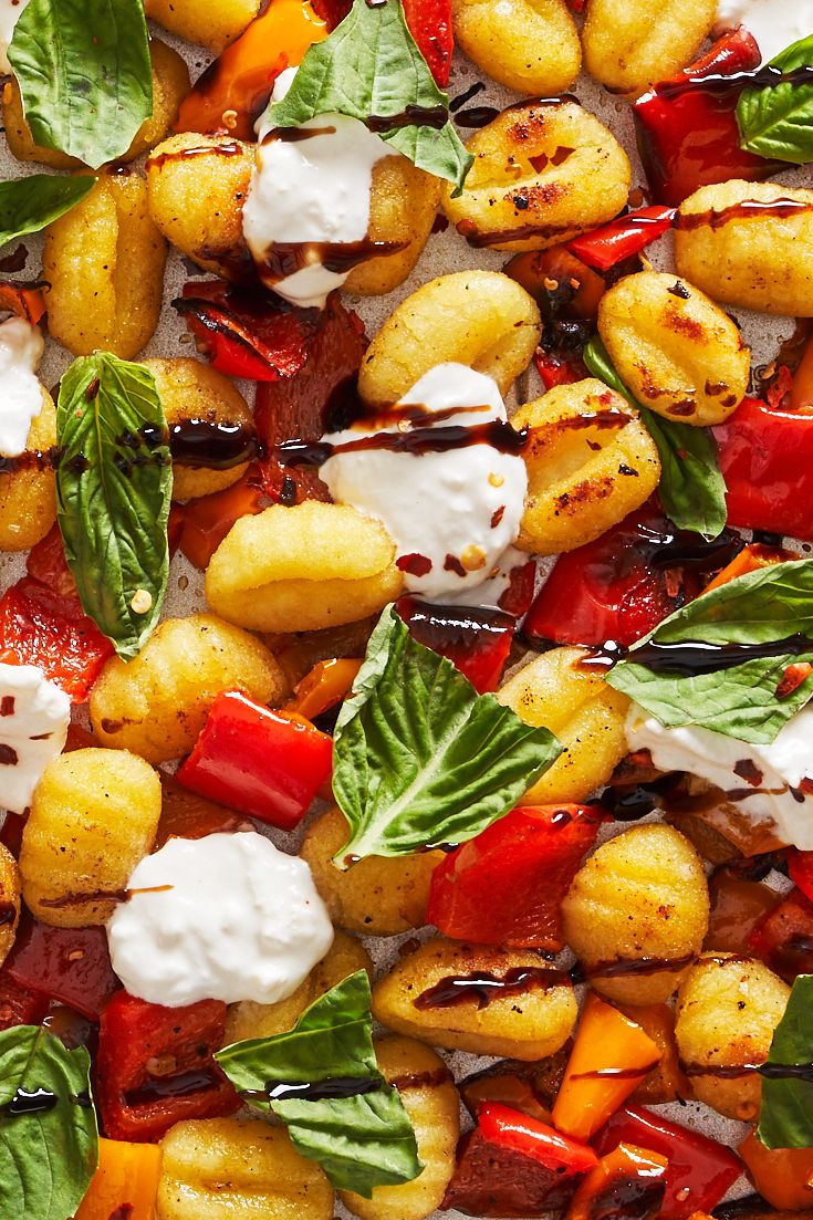 gnocchi, burrata, tomatoes, and basil drizzled with balsamic reduction on a sheet pan