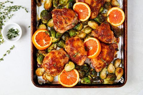 citrus glazed chicken, brussels sprouts, and orange slices on a sheet pan